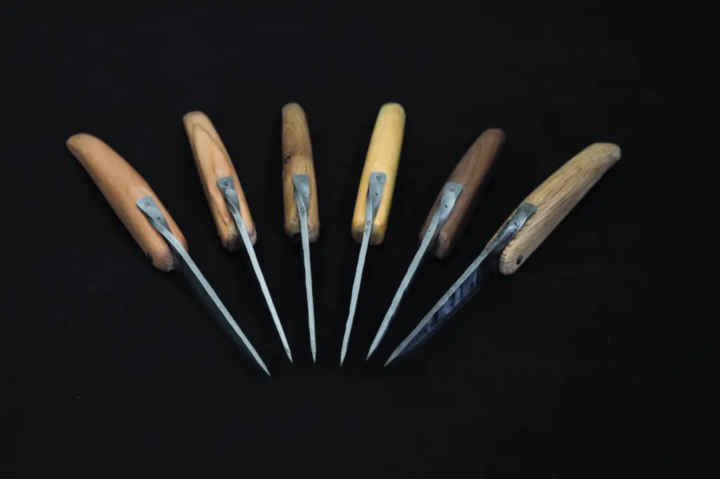 Six Barachin knives open, seen from the handle end, points converging and the lever visible on each