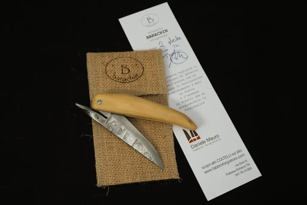 A Barachin with a boxwood handle resting on the jute bag stamped Barachin, beside the signed certificate of guarantee