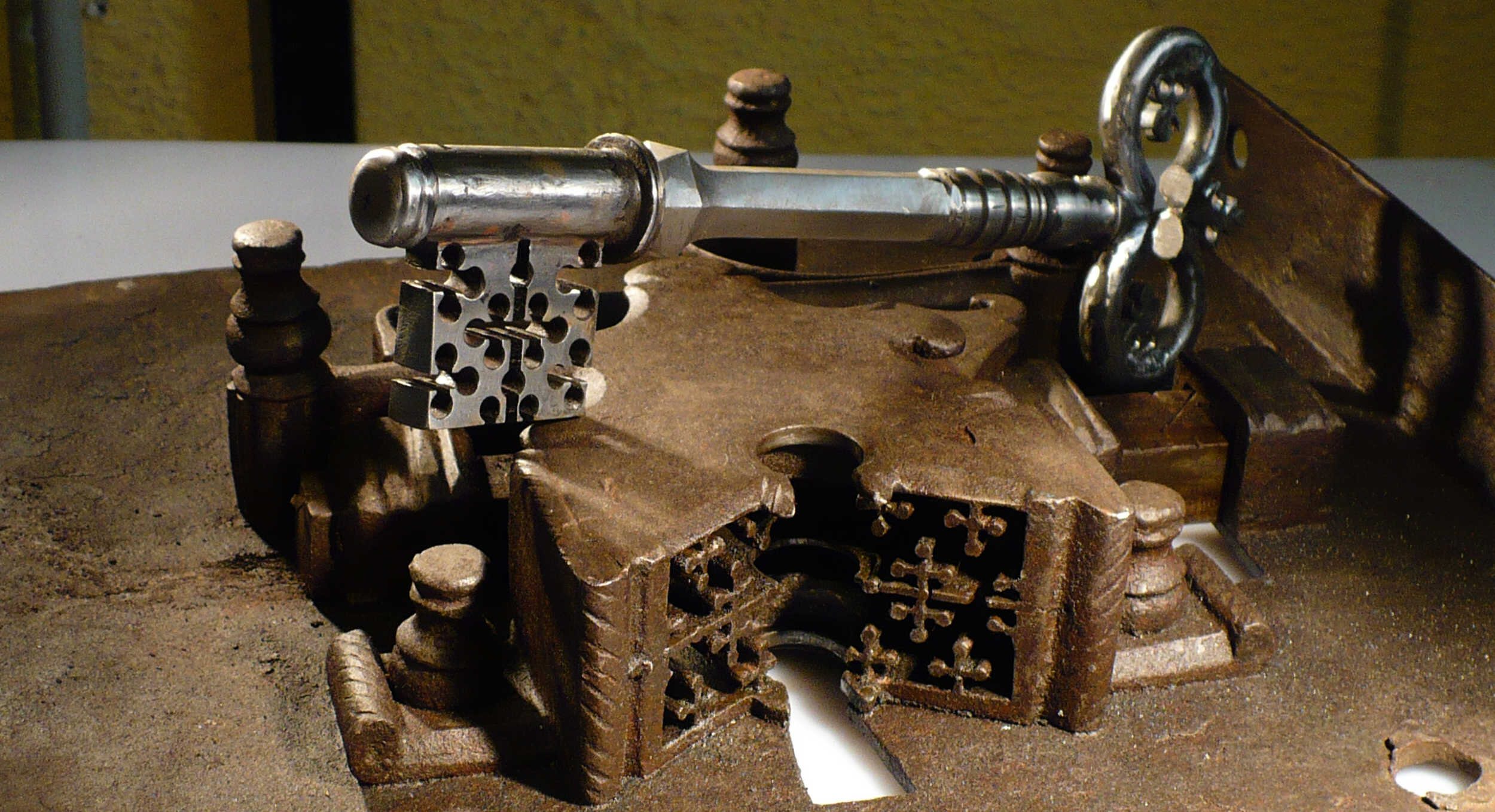 Key with a fretwork bit resting on a sixteenth-century strongbox lock