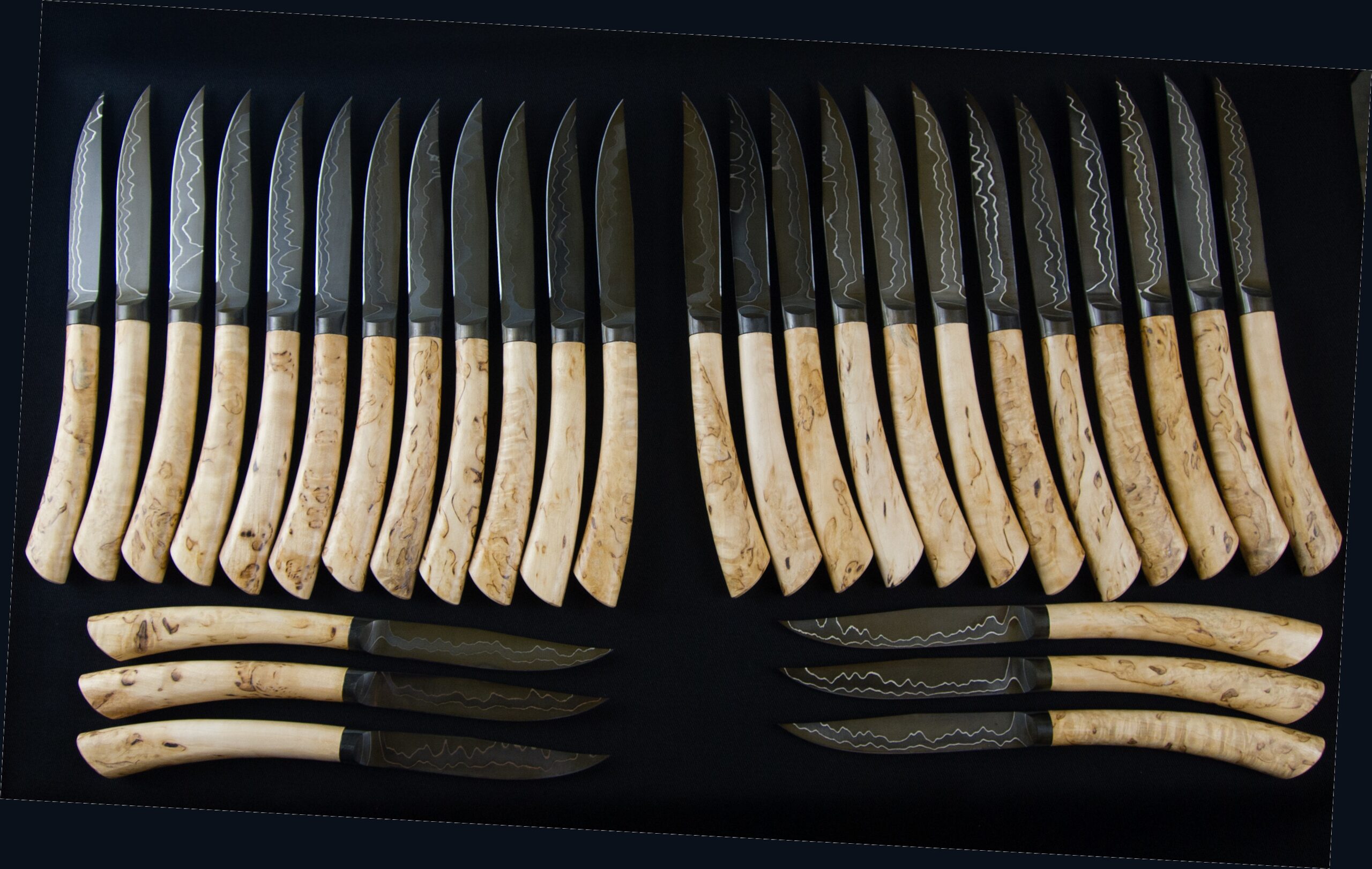 Twenty-four table knives with Damascus steel blades and light birch handles