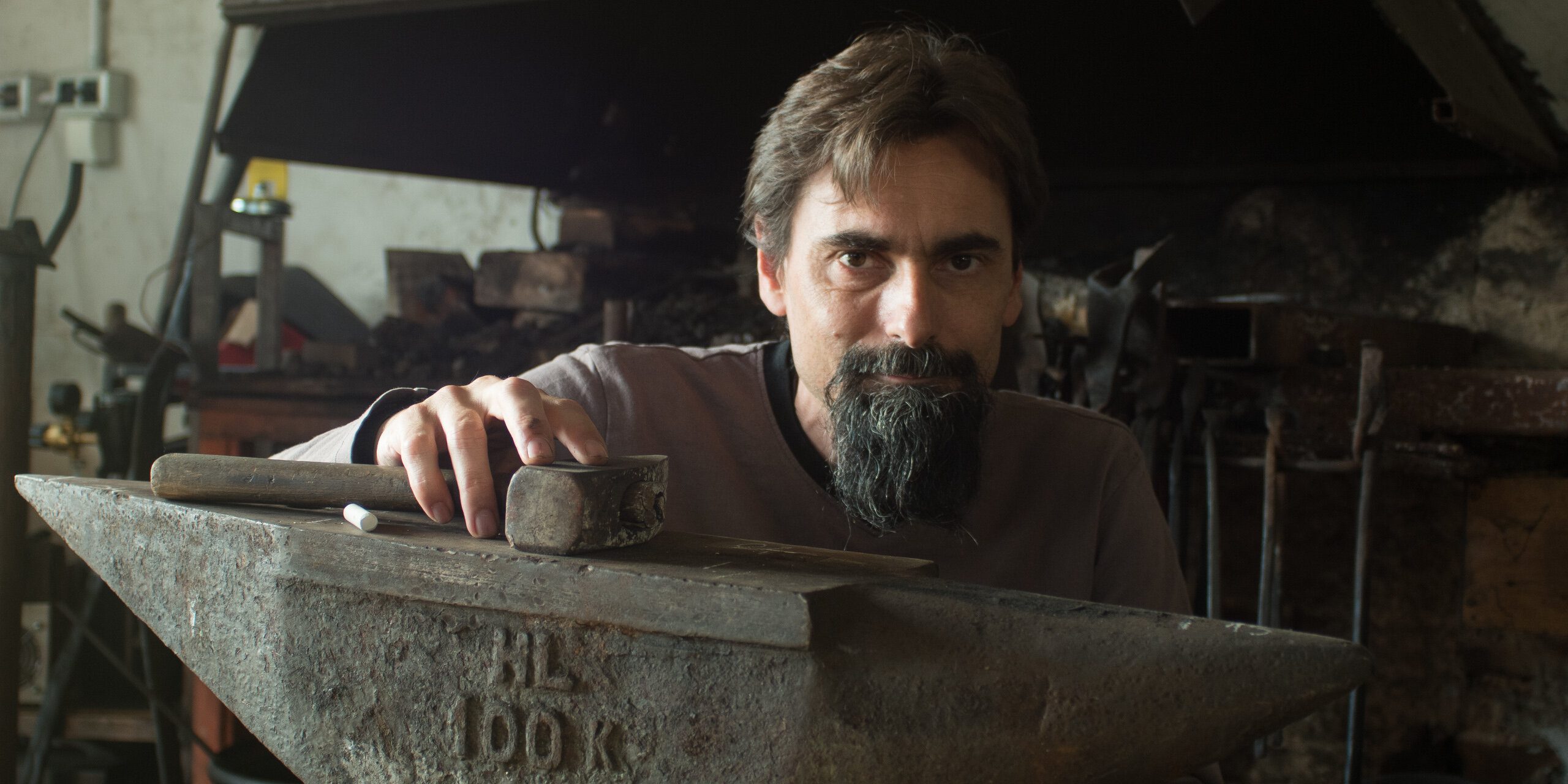 Daniele Mauro, blacksmith and forger, behind the anvil in his workshop